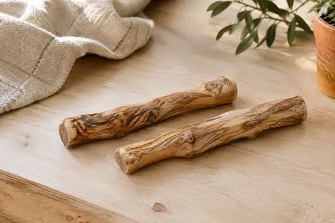 Deux bâtons à mâcher en bois d’olivier naturel posés sur un sol en bois clair