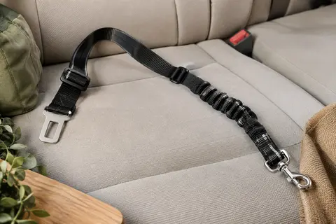 Sangle de voiture noire réglable avec partie élastique, bande réfléchissante et mousqueton métallique.