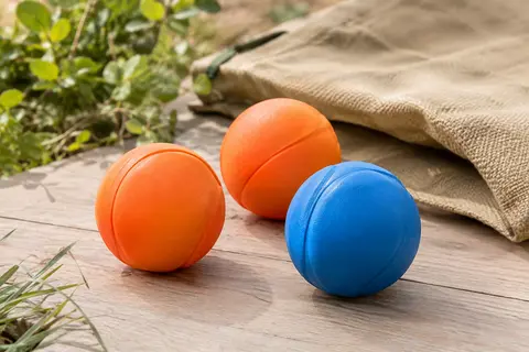 Trois balles orange et bleues en caoutchouc pour les jeux de rapport du chien