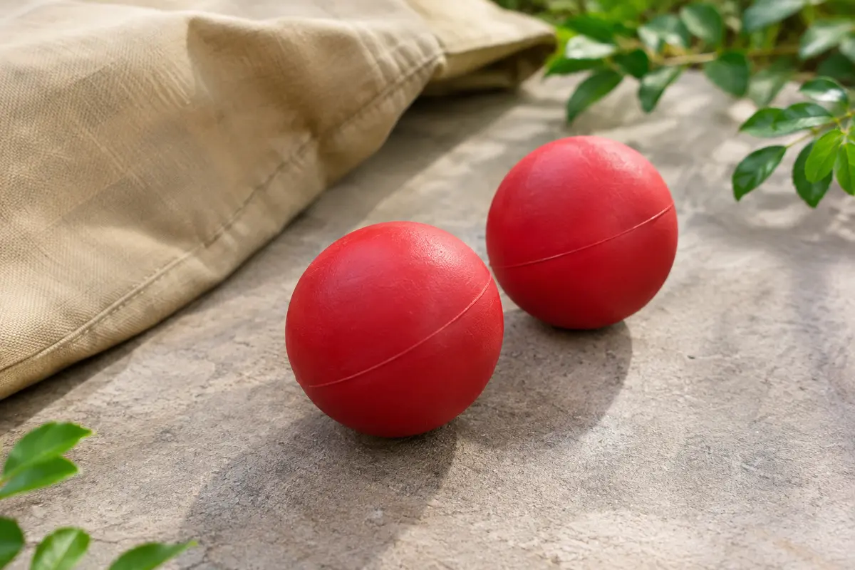 Deux balles rouges en caoutchouc posées sur un chemin de promenade au décor naturel