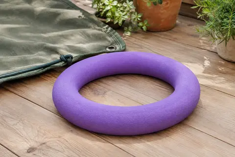 Anneau de traction mauve pour chien, en EVA souple, posé sur un sol en bois clair